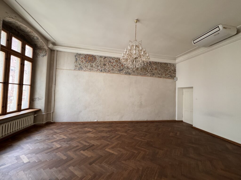 Kanonicza 15 – room with a parquet floor and a chandelier